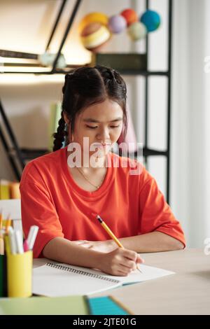 Schoolgirl looking through homework Stock Photo - Alamy