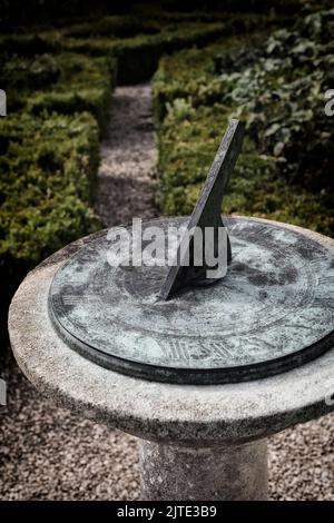 A sundial in the formal walled garden of an English country house. Stock Photo