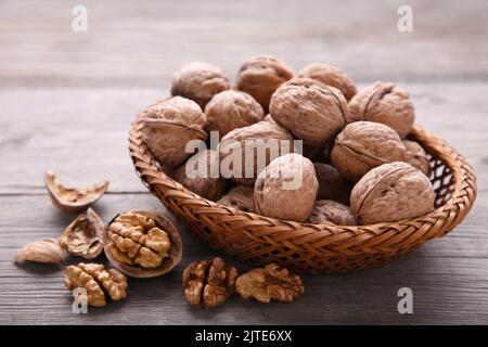 Walnuts kernels in basket on grey wooden background. Walnuts kernels on grey wooden table Stock Photo