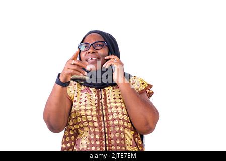 happy muslim mature woman wearing glasses talking on cellphone gesturing hand. Stock Photo