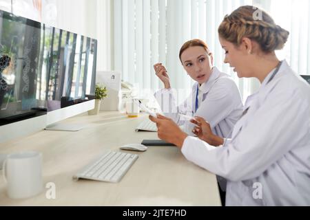 Serious female scientists discussing results of research they were working on Stock Photo