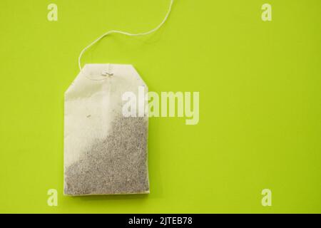 Tea bag on vivid green table, copy space. Stock Photo