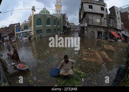 Lahore, Punjab, Pakistan. 29th Aug, 2022. Pakistani people on their way and busy in Badami bagh vegetable market during heavy monsoon rainfall in Lahore. Fourt spell of monsoon rain has broken a 20-year record as the provincial capital received 248mm of downfall in Eight hours. At least Five persons dead and many injured after two roof and walls collapse and other incidents in provincial capital city Lahore. (Credit Image: © Rana Sajid Hussain/Pacific Press via ZUMA Press Wire) Stock Photo