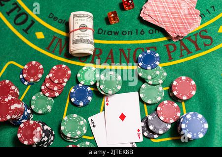 A closeup cards and different chips spread on a poker table Stock Photo