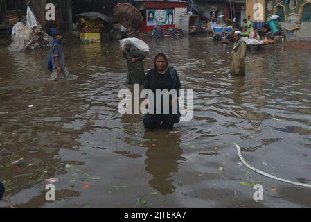 Lahore, Punjab, Pakistan. 29th Aug, 2022. Pakistani people on their way and busy in Badami bagh vegetable market during heavy monsoon rainfall in Lahore. Fourt spell of monsoon rain has broken a 20-year record as the provincial capital received 248mm of downfall in Eight hours. At least Five persons dead and many injured after two roof and walls collapse and other incidents in provincial capital city Lahore. (Credit Image: © Rana Sajid Hussain/Pacific Press via ZUMA Press Wire) Stock Photo