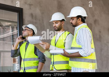 male architects in helmets working at office Stock Photo