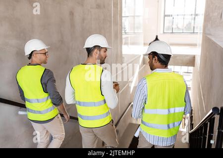 architects in helmets walking downstairs at office Stock Photo