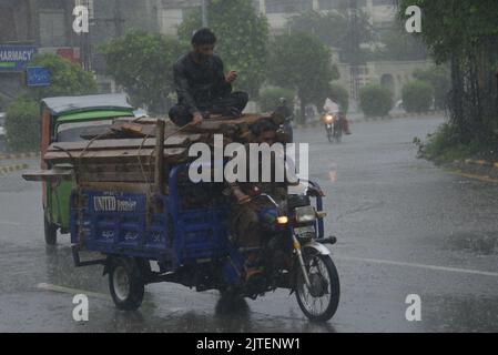 Lahore, Punjab, Pakistan. 29th Aug, 2022. Pakistani people on their way and busy in Badami bagh vegetable market during heavy monsoon rainfall in Lahore. Fourt spell of monsoon rain has broken a 20-year record as the provincial capital received 248mm of downfall in Eight hours. At least Five persons dead and many injured after two roof and walls collapse and other incidents in provincial capital city Lahore. (Credit Image: © Rana Sajid Hussain/Pacific Press via ZUMA Press Wire) Stock Photo