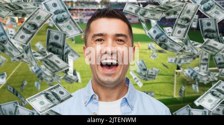 happy man over money rain on football field Stock Photo