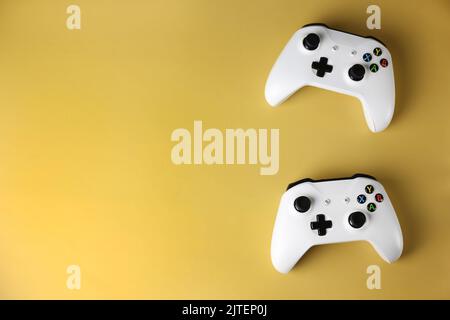 Two gaming gamepads on the side on an isolated yellow background Stock Photo