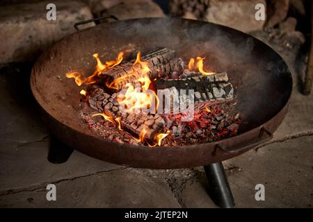 Fire in a flame pit at a campsite Stock Photo