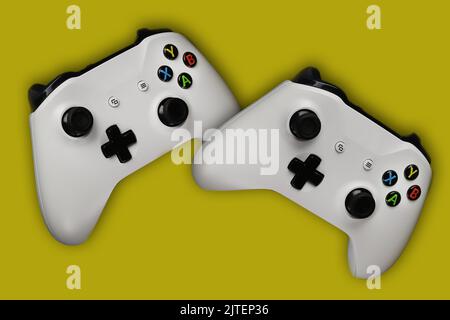Two gaming gamepads in flight on an isolated yellow background Stock Photo