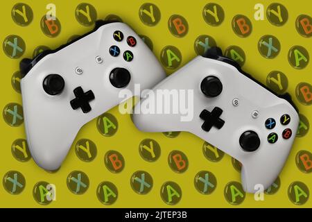 Two gaming gamepads in flight on a yellow background with buttons for games Stock Photo
