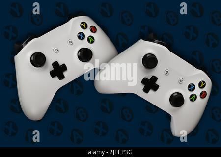 Two gaming gamepads in flight on a dark blue background with buttons for games Stock Photo