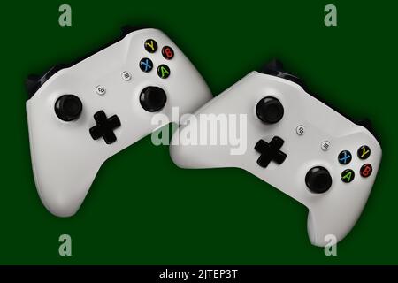 Two gaming gamepads in flight on an isolated dark green background Stock Photo