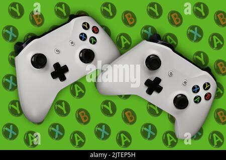 Two gaming gamepads in flight on a green background with buttons for games Stock Photo