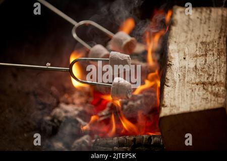 Fire in a flame pit at a campsite toasting marshmallows Stock Photo