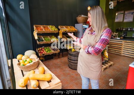 Portrait of happy food supermarket owner. Woman works in fruits and vegetables shop. Stock Photo
