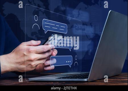 The concept of chatting in the global Internet network via messengers. person is holding a smartphone with a hologram. Stock Photo