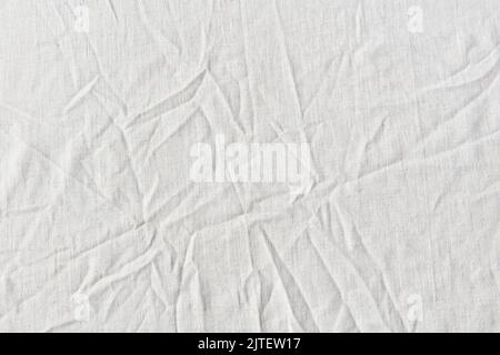 Natural crumpled white linen textile. Stock Photo