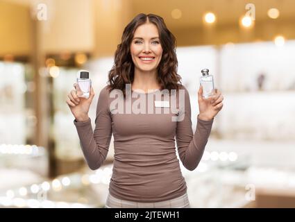 happy female shop assistant with perfume Stock Photo