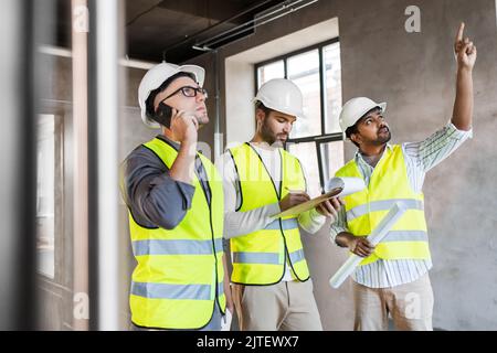 male architects in helmets working at office Stock Photo