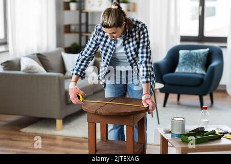 woman with ruler measuring table for renovation Stock Photo