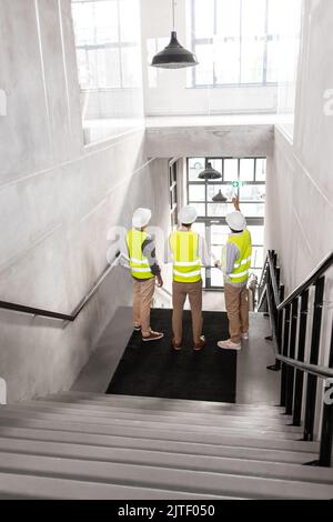architects in helmets with blueprints at office Stock Photo