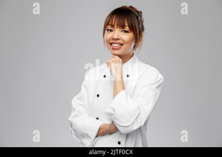 smiling female chef in white jacket Stock Photo