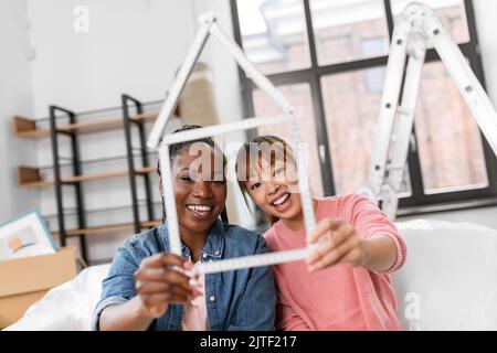 happy smiling women with ruler in shape of house Stock Photo