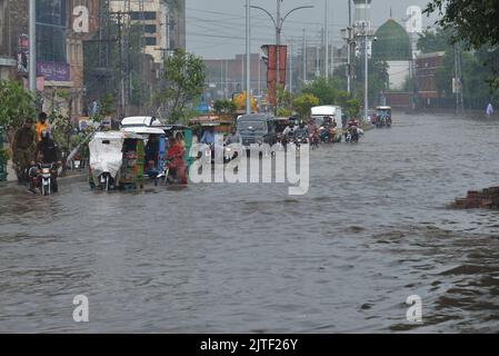 Lahore, Pakistan. 29th Aug, 2022. Pakistani people on their way and busy in Badami bagh vegetable market during heavy monsoon rainfall in Lahore, Pakistan on August 29, 2022. The monsoon rain has broken a 20-year record as the provincial capital received 248mm of downfall in Eight hours. At least Five people are dead and many injured after two roof and walls collapse and other incidents in provincial capital city Lahore. (Photo by Rana Sajid Hussain/Pacific Press/Sipa USA) Credit: Sipa USA/Alamy Live News Stock Photo