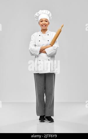 smiling female chef or baker with rolling pin Stock Photo