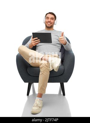 man with headphones and tablet pc shows thumbs up Stock Photo