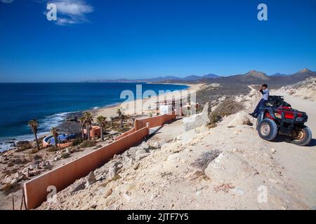 Cabo San Lucas, Mexico - February 12, 2011:  Tourist viewing the Sea of Cortez on an ATV on the beaches of Cabo San Lucas, Mexico. Stock Photo