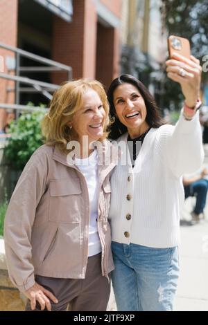 Smiling female friends taking selfie Stock Photo