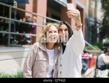 Smiling female friends taking selfie Stock Photo
