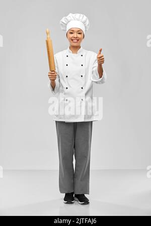 smiling female chef or baker with rolling pin Stock Photo