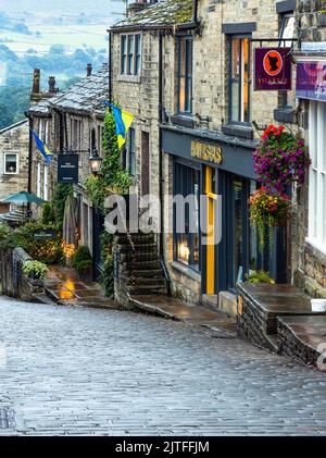 Cottages, shops and cafes on Haworth Main Street in Yorkshire. Haworht is famous for being the home of the Bronte sisters. Stock Photo