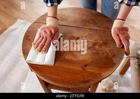 woman cleaning old table surface with paper tissue Stock Photo