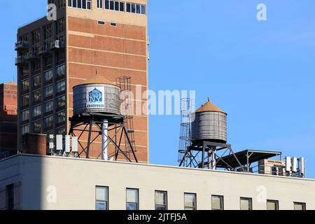 Rosenwach wood water tanks on a New York City rooftop. Water tanks are used to store water to maintain water pressure in a building. Stock Photo