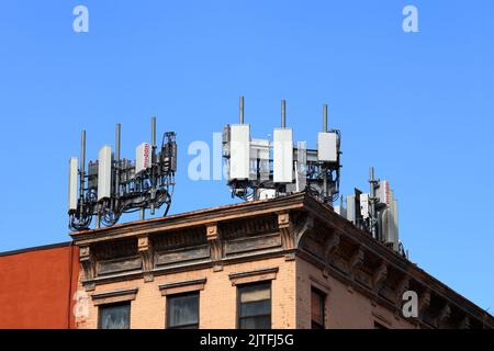 Mobile telecommunications equipment on a rooftop with LTE 4G 5G network transmitters, wifi, wireless, other cellphone antennas, and infrastructure Stock Photo