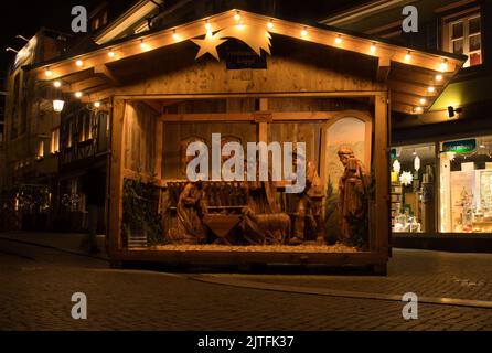 Gengenbach, Germany - December 13, 2020: Nativity scene made of wood in the city of Gengenbach, Germany on a fall night during lockdown. Stock Photo