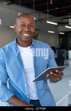 Cropped shot of a young  businessman standing in his office and using a tablet, Spain Stock Photo