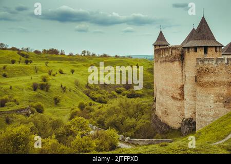 Old brick fortress in Khotyn. Ancient castle, green meadow hills. Majestic fortification on the banks of Dniester River, famous large castle in Ukraine. Travel, adventure. Vintage retro tone filter Stock Photo