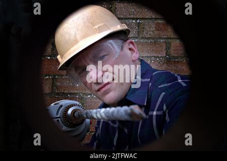 Man drilling a hole Stock Photo