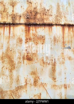 Corroded metal background. Rusted white painted metal wall. Rusty metal background with streaks of rust. Rust stains. The metal surface rusted spots. Stock Photo