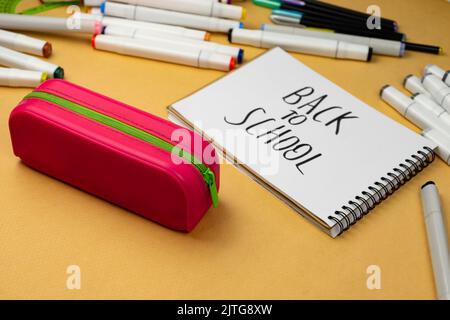 Back to school is written in black marker on a white notebook. School background Stock Photo
