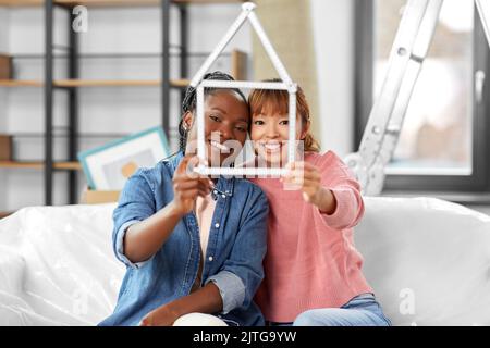 happy smiling women with ruler in shape of house Stock Photo