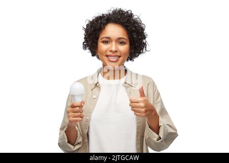 happy smiling woman holding lighting bulb Stock Photo