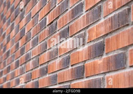 Brick red wall with uneven texture. Exterior decorative rough surface of the facade of the building. Close-up Stock Photo